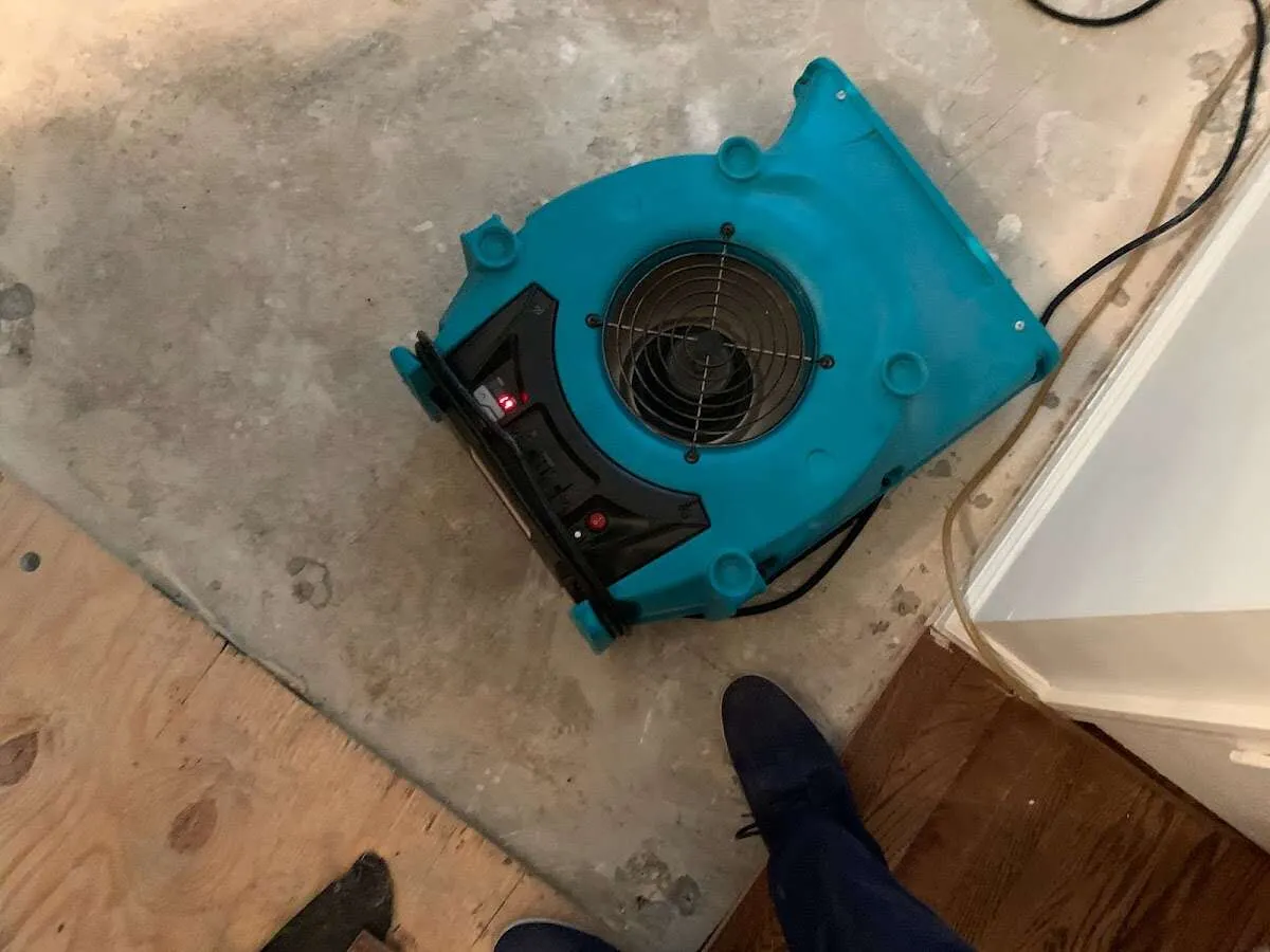 Air mover drying subfloor during Commercial Water Damage Restoration in New River